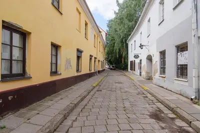 an empty cobblestone street in a city with buildings at Zydu str two bedrooms Apartment by URBAN RENT in Vilnius