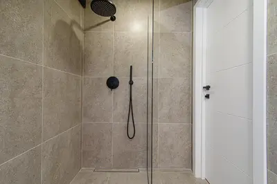 a bathroom with a shower with a shower head at Zydu str two bedrooms Apartment by URBAN RENT in Vilnius