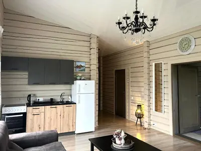 a kitchen with a white refrigerator and a table at Lazariškio apartamentai in Martyniškėnai