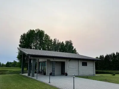 a small white building with a roof at Lazariškio apartamentai in Martyniškėnai