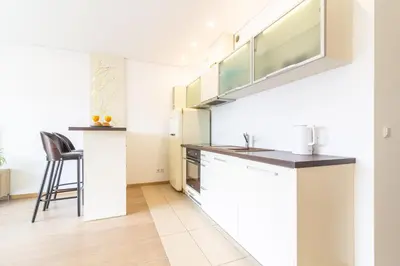 a kitchen with white cabinets and a counter top at Sunny Center Apt, Covered Parking, Balcony & Self Check-in in Kaunas