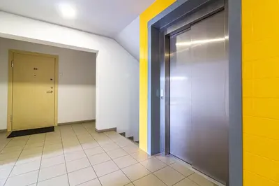 a hallway with a metal door and a yellow wall at Sunny Center Apt, Covered Parking, Balcony & Self Check-in in Kaunas