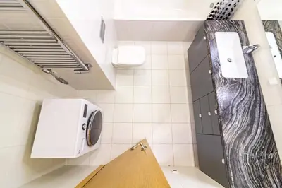 a bathroom with a washer and dryer on the wall at Sunny Center Apt, Covered Parking, Balcony & Self Check-in in Kaunas