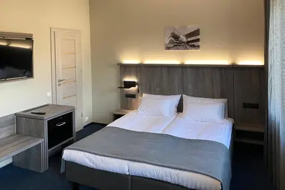 a hotel room with a bed and a television at Brut Wine Hotel in Zarasai