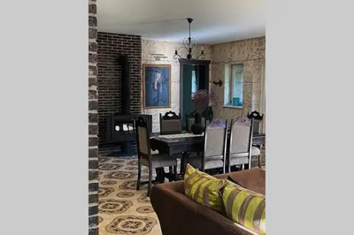 a living room with a couch and a dining room at Forest house for family in Lebeniškiai