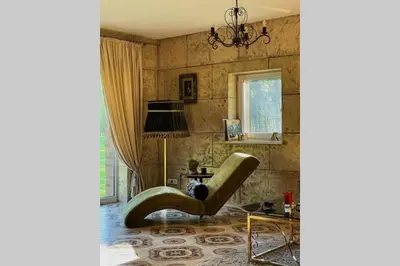 a living room with a green chair and a table at Forest house for family in Lebeniškiai