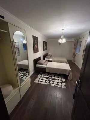 a bedroom with two beds and a large mirror at Forest house for family in Lebeniškiai