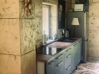 a kitchen with blue cabinets and a sink and a window at Forest house for family in Lebeniškiai