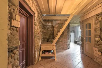 a staircase in a room with a brick wall at Super Sodyba in Pamusiai