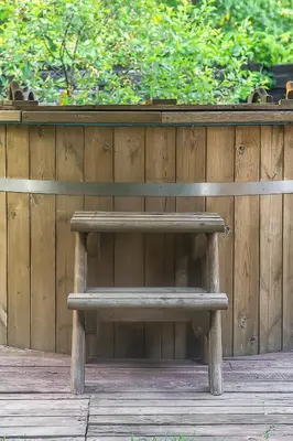 a wooden bench sitting in front of a wooden fence at Super Sodyba in Pamusiai