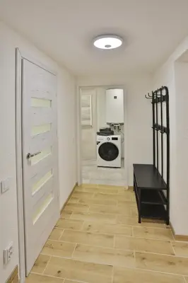 a room with a hallway with a door and a kitchen at River Park apartments Ukmerge in Ukmergė