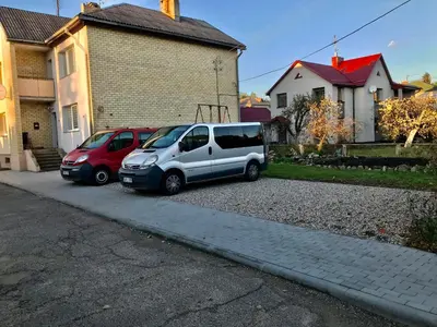 two cars parked in a driveway next to a house at River Park apartments Ukmerge in Ukmergė
