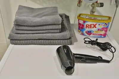 a bathroom counter with a hair dryer and a towel at River Park apartments Ukmerge in Ukmergė