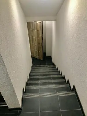 a hallway with a staircase with a door at River Park apartments Ukmerge in Ukmergė