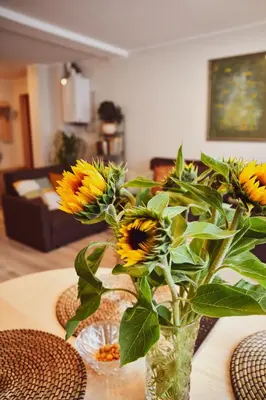 a vase filled with yellow flowers on a table at Central Park Apartment Birštonas in Birštonas