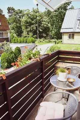 a patio with a table and chairs on a fence at Central Park Apartment Birštonas in Birštonas