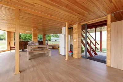 a living room with a wooden ceiling and a table at Brazylija VIP vasarnamis in Kryliai