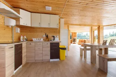 a kitchen with white cabinets and a wooden ceiling at Brazylija VIP vasarnamis in Kryliai