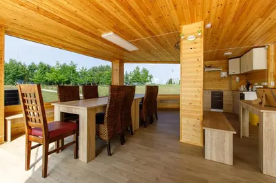 a kitchen and dining room with a wooden ceiling at Brazylija VIP vasarnamis in Kryliai
