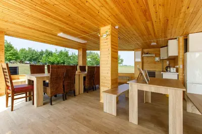 a kitchen and dining room with a wooden ceiling at Brazylija VIP vasarnamis in Kryliai