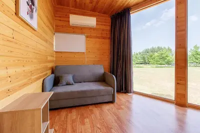 a living room with a couch and a large window at Brazylija VIP vasarnamis in Kryliai