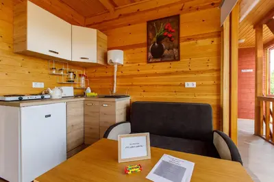 a kitchen with a table with a chair and a counter at Brazylija VIP vasarnamis in Kryliai