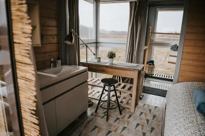 a tiny house with a sink and a bed at Vienkiemio oazė - Skandinaviškas namelis su vaizdu į tvenkinį in Galvokai