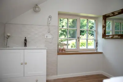 a white kitchen with a sink and a window at Domingo vila in Krosna