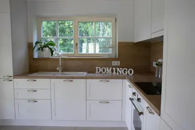 a white kitchen with a sink and a window at Domingo vila in Krosna