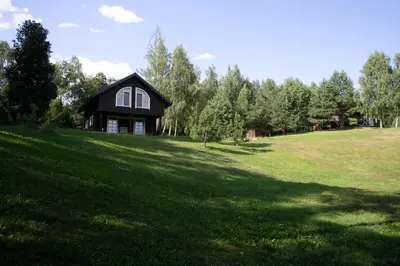a house on a hill with a large grass field at Domingo vila in Krosna