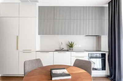 a kitchen with a wooden table and chairs at Luxurious Apartment in Vilnius Old Town by Reside Baltic in Vilnius