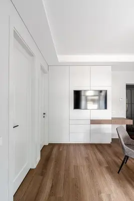a white living room with a chair and a television at Luxurious Apartment in Vilnius Old Town by Reside Baltic in Vilnius