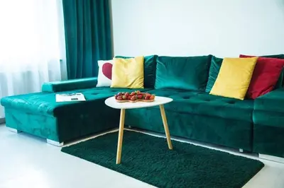 a green couch with a table in a living room at LYRA63 Large 80sq m TOP 14 floor in Šiauliai