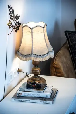 a lamp sitting on top of a table with books at LYRA63 Large 80sq m TOP 14 floor in Šiauliai