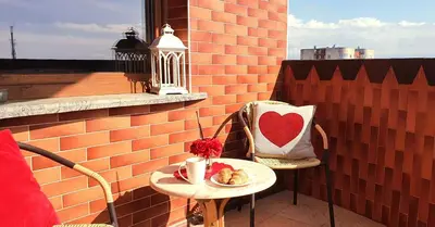 a table with a cup of coffee and a heart pillow at LYRA63 Large 80sq m TOP 14 floor in Šiauliai