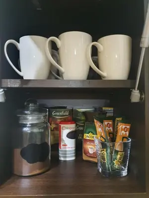 a shelf with cups and cups and other items on it at LYRA63 Large 80sq m TOP 14 floor in Šiauliai