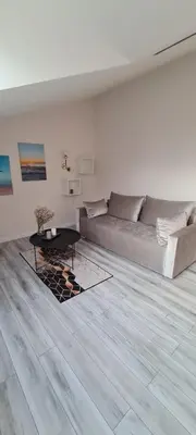a living room with a couch and a table at Jaukus butas Vilniuje Žvėryno rajone in Vilnius