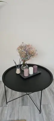 a black table with two vases and flowers on it at Jaukus butas Vilniuje Žvėryno rajone in Vilnius