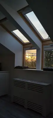 a room with two windows and a radiator in front of a window at Jaukus butas Vilniuje Žvėryno rajone in Vilnius