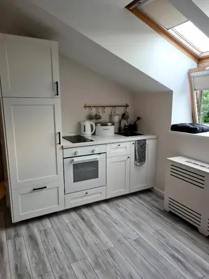 a kitchen with white cabinets and a stove at Jaukus butas Vilniuje Žvėryno rajone in Vilnius