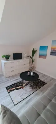 a living room with a table and a tv at Jaukus butas Vilniuje Žvėryno rajone in Vilnius
