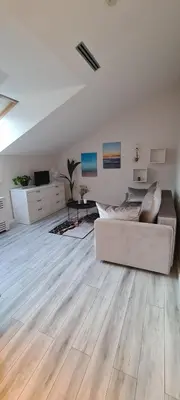 a large white living room with a couch and wooden floors at Jaukus butas Vilniuje Žvėryno rajone in Vilnius
