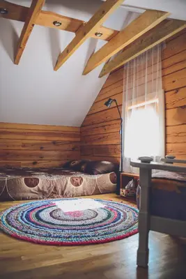 a room with a rug on the floor and a lamp at Namelis Rudnios kaime “Nykštukas” in Rudnia