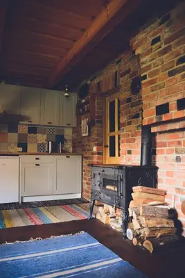 a kitchen with a stove and a brick wall at Namelis Rudnios kaime “Nykštukas” in Rudnia