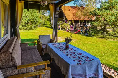 a table on the back porch of a house at Namelis Rudnios kaime “Nykštukas” in Rudnia