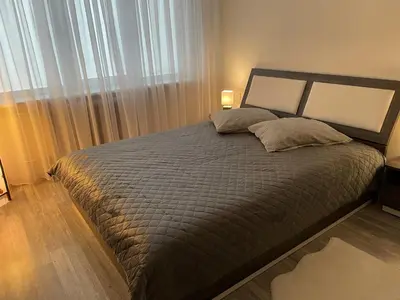 a bedroom with a large bed with a large window at Ateities 3044 Self CHECK In in Panevėžys
