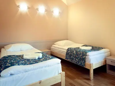 a room with two beds and lights on the wall at Kamanos in Utena