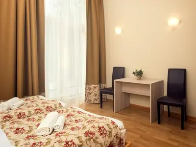 a hotel room with a bed and a table and chairs at Kamanos in Utena