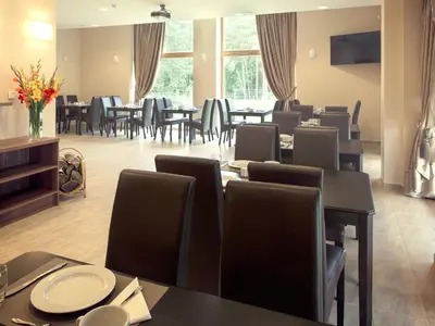 a restaurant with tables and chairs and a dining room at Kamanos in Utena