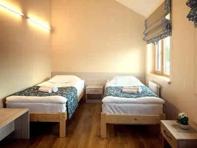 a small room with two beds and a table at Kamanos in Utena